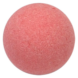 A pink ball of soap sitting on top of a white surface.