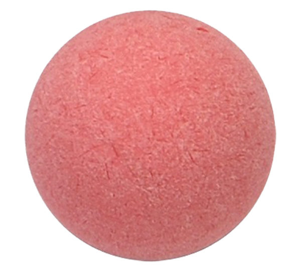 A pink ball of soap sitting on top of a white surface.