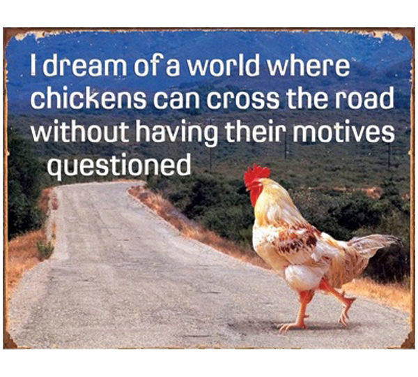 A chicken standing on the side of a road.