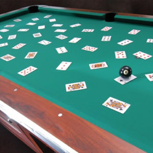 A pool table with playing cards on it.