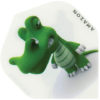 A green toy alligator is sitting on top of a white surface.